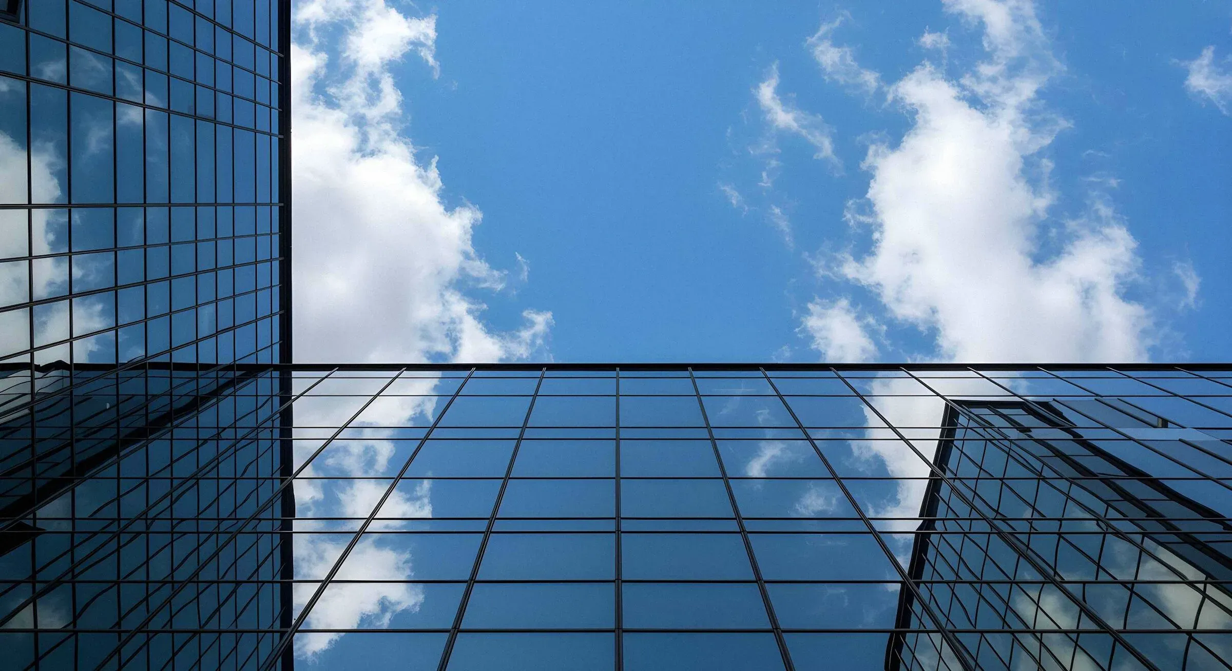 Corporate glass facade reflecting sky